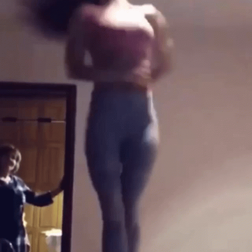 A Woman Is Standing In Front Of A Mirror And Taking A Picture Of Herself GIF