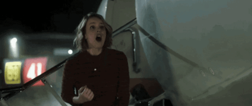 A Woman Is Standing In Front Of A Plane With The Number 41 On The Side GIF