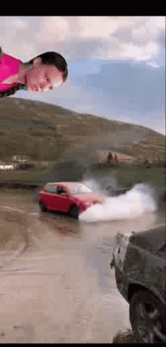 A Woman Is Standing In Front Of A Red Car That Is Drifting In The Water . GIF