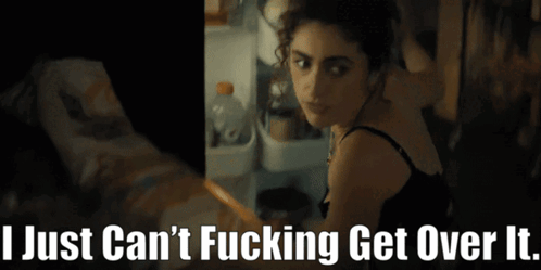 A Woman Is Standing In Front Of A Refrigerator With The Words " I Just Can 'T Fucking Get Over It " Below Her GIF