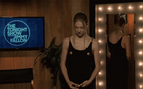 A Woman Is Standing In Front Of A Screen That Says Jimmy Fallon GIF