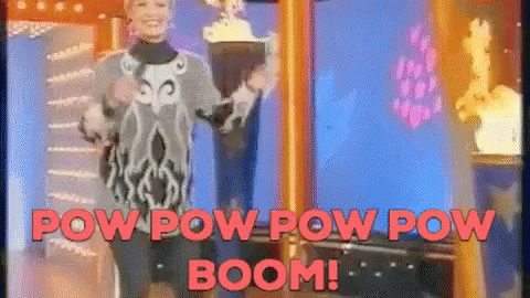 A Woman Is Standing In Front Of A Screen That Says Pow Pow Pow Boom GIF