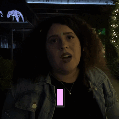 A Woman Is Standing In Front Of A Sign That Says Chihuly Garden Glass GIF