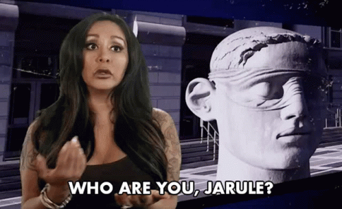 A Woman Is Standing In Front Of A Statue And Asking Who Are You Jarule GIF