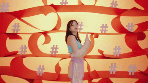 A Woman Is Standing In Front Of A Wall Of Hashtags GIF