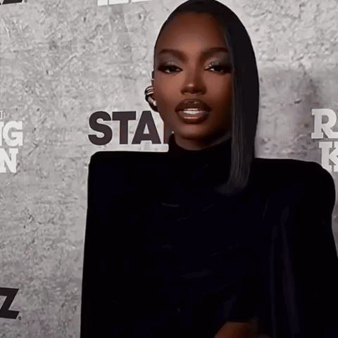 a woman is standing in front of a wall that says star