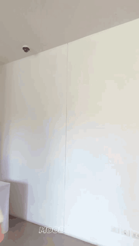 A Woman Is Standing In Front Of A White Wall And Smiling GIF