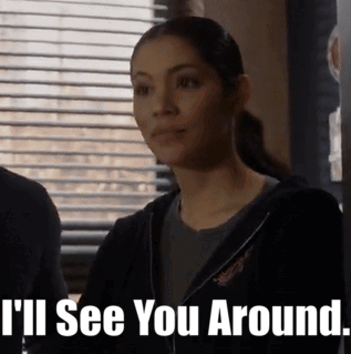 A Woman Is Standing In Front Of A Window With Blinds And Says I 'Ll See You Around . GIF
