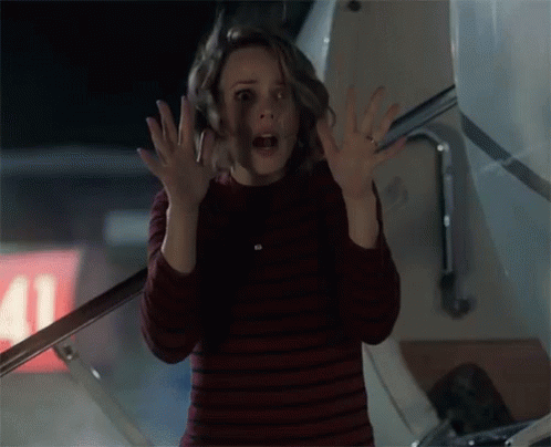 A Woman Is Standing In Front Of An Airplane With Her Hands Up In The Air . GIF