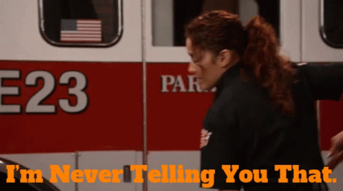 A Woman Is Standing In Front Of An Ambulance With The Number 23 On It GIF