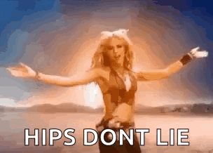 A Woman Is Standing In The Desert With Her Arms Outstretched And Says Hips Dont Lie GIF