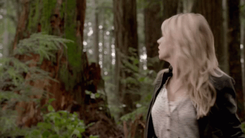 Woman Standing In Forest Looking Up At Sky GIF