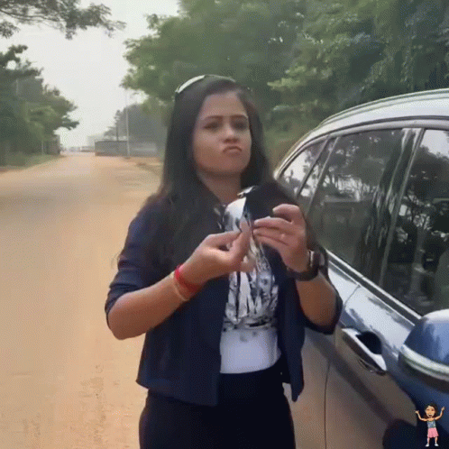 A Woman Is Standing Next To A Car Holding A Key GIF