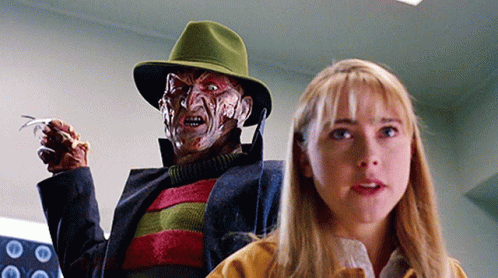 a woman is standing next to a freddy krueger doll