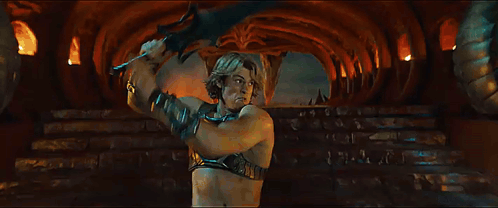 A Woman Is Standing Next To A Man In A Dark Room With A Sword . GIF