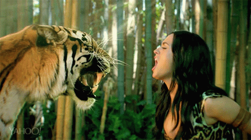 A Woman Is Standing Next To A Tiger With Yahoo Written On The Bottom Right GIF