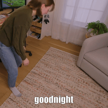 A Woman Is Standing On A Rug With The Words Goodnight Written On It GIF