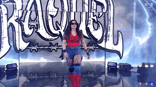 A Woman Is Standing On A Stage In Front Of A Sign That Says ' Rage ' On It . GIF