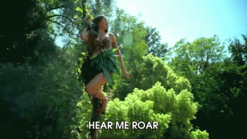 A Woman Is Standing On A Tree Branch With The Words Hear Me Roar Written Below Her GIF