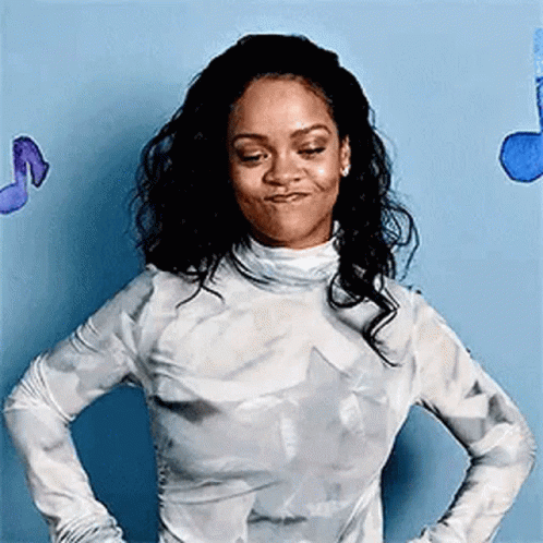 A Woman Is Standing With Her Hands On Her Hips In Front Of A Blue Wall With Music Notes . GIF