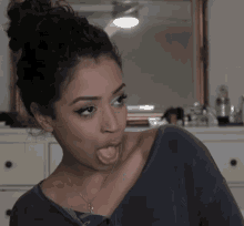 A Woman Is Sticking Her Tongue Out And Making A Funny Face GIF