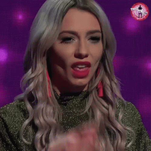 A Woman Is Sticking Her Tongue Out In Front Of A Purple Screen . GIF
