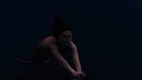 a woman is swimming in a body of water
