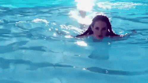 A Woman Is Swimming In A Pool With Her Hair Visible . GIF