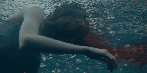 A Woman Is Swimming In A Pool With Her Head Down GIF