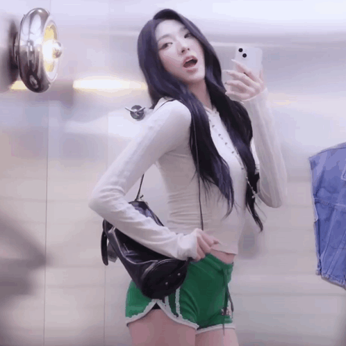 A Woman Is Taking A Picture Of Herself In A Mirror GIF