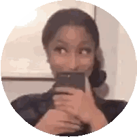 a woman is taking a picture of herself in a mirror with her phone .