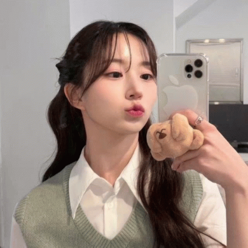 A Woman Is Taking A Picture Of Herself In The Mirror GIF