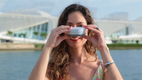 A Woman Is Taking A Picture Of Herself With A Camera GIF
