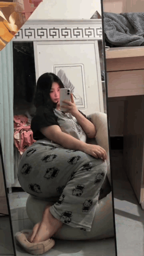 A Woman Is Taking A Selfie In Front Of A Mirror With Chinese Characters On It GIF