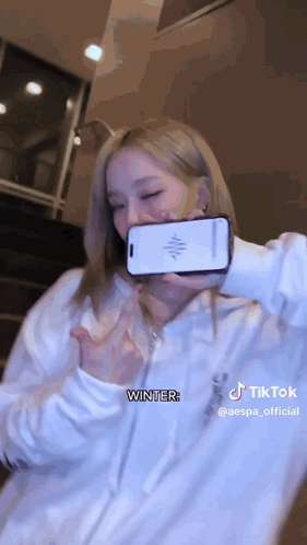 A Woman Is Taking A Selfie With A Cell Phone In Her Hand . GIF