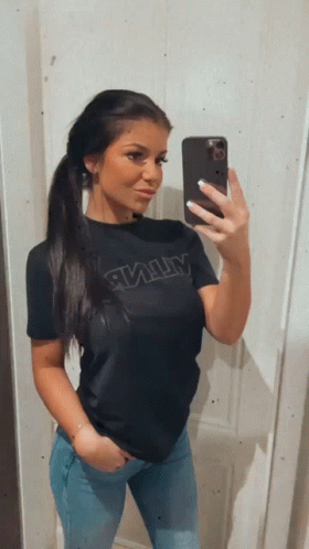 A Woman Is Taking A Selfie With Her Phone While Wearing A Black Shirt With The Word Army On It GIF