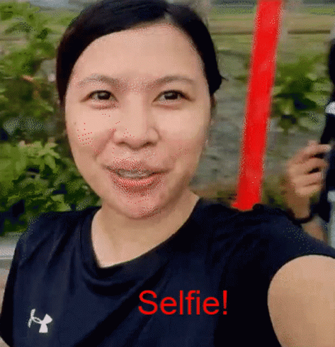 A Woman Is Taking A Selfie With The Words Selfie Written In Red GIF