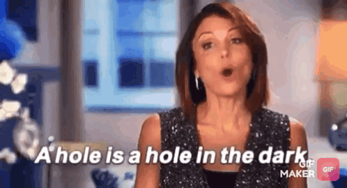 A Woman Is Talking About A Hole In The Dark While Wearing A Sequined Top . GIF