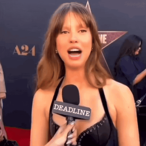 A Woman Is Talking Into A Microphone With The Word Deadline On It GIF