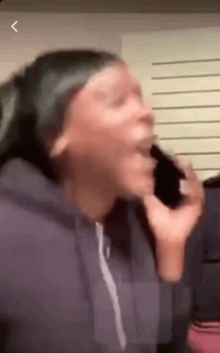 A Woman Is Talking On A Cell Phone And Making A Face . GIF