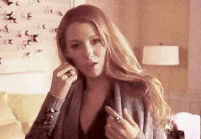 A Woman Is Talking On A Cell Phone In A Living Room While Wearing A Ring On Her Finger . GIF