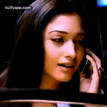 A Woman Is Talking On A Cell Phone While Looking At The Rear View Mirror . GIF