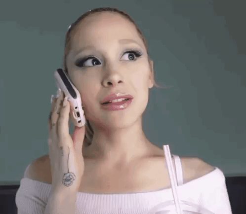 A Woman Is Talking On A Cell Phone While Making A Funny Face . GIF