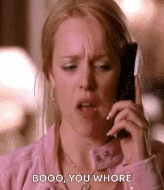 A Woman Is Talking On A Cell Phone While Making A Funny Face . GIF