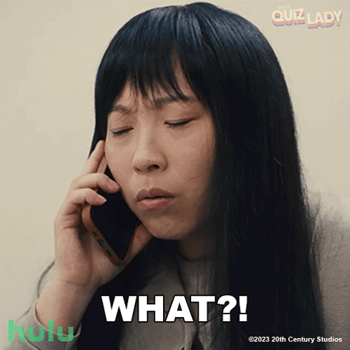 A Woman Is Talking On A Cell Phone With The Words What Written Below Her GIF