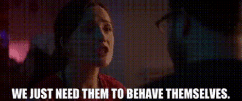 A Woman Is Talking To A Man In A Dark Room And The Words We Just Need Them To Behave Themselves Are Visible . GIF