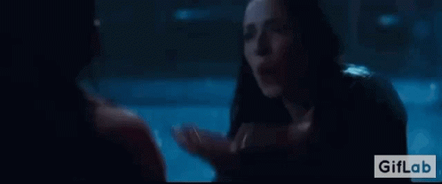A Woman Is Talking To A Man In A Dark Room In A Movie . GIF