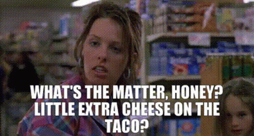 A Woman Is Talking To Another Woman In A Grocery Store While Holding A Taco . GIF
