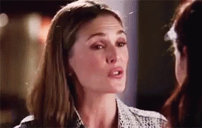 A Woman Is Talking To Another Woman In A Room And Looking At The Camera . GIF