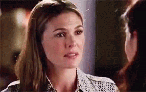 A Woman Is Talking To Another Woman While Looking At Her Face . GIF
